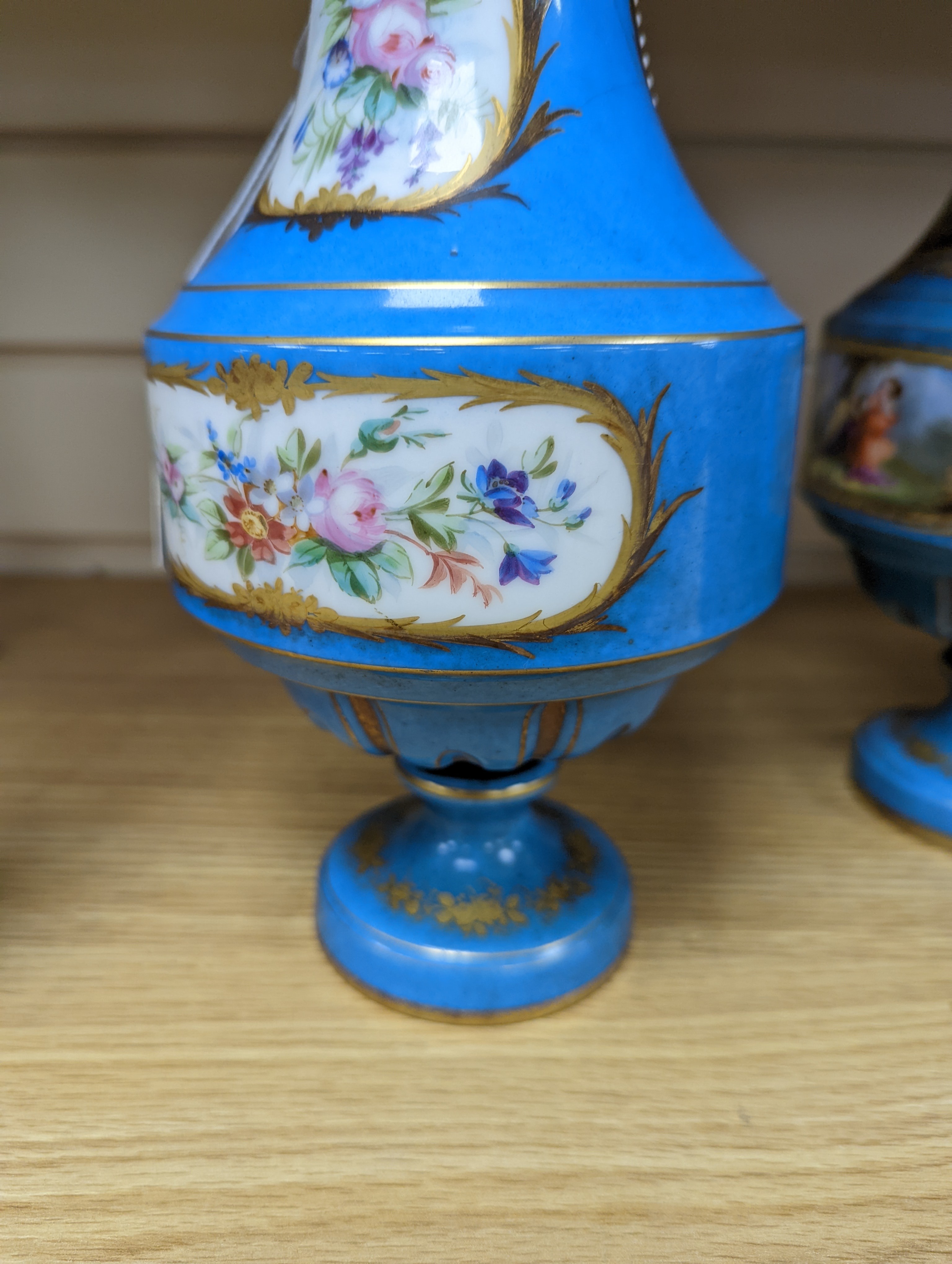 A pair of Sevres style porcelain bleu celeste ground vases and covers, 34cm